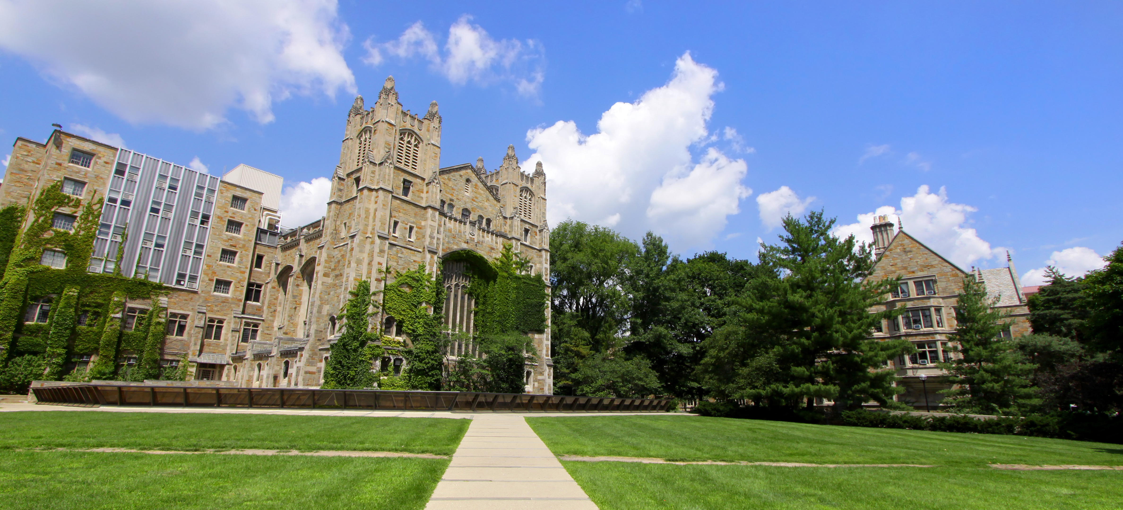 College campus with stone buildings, grass and trees on a sunny day